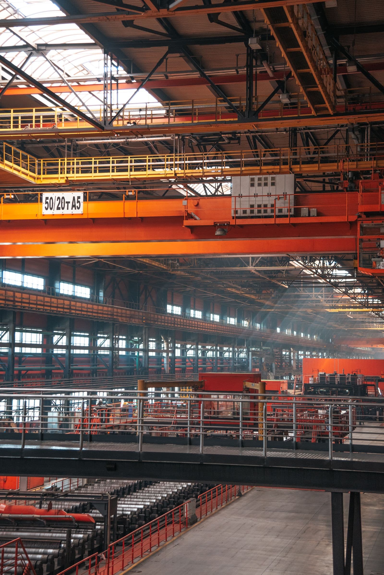 Industrial factory interior with overhead cranes and large-scale steel handling